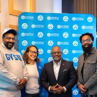 Group of four event attendees standing for photo in front of GV back drop